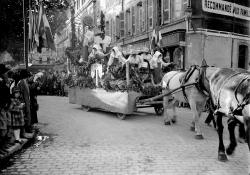 Elle montre l’un des chars dédiés à la célébration des vendanges et des métiers de la vigne alors qu’il parcourt la ville pavoisée de drapeaux français. 